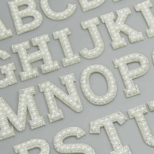 White pearl silver rhinestone iron-on patch letters showing a section of the alphabet. Used by brides for wedding party attire and personalising clothing.